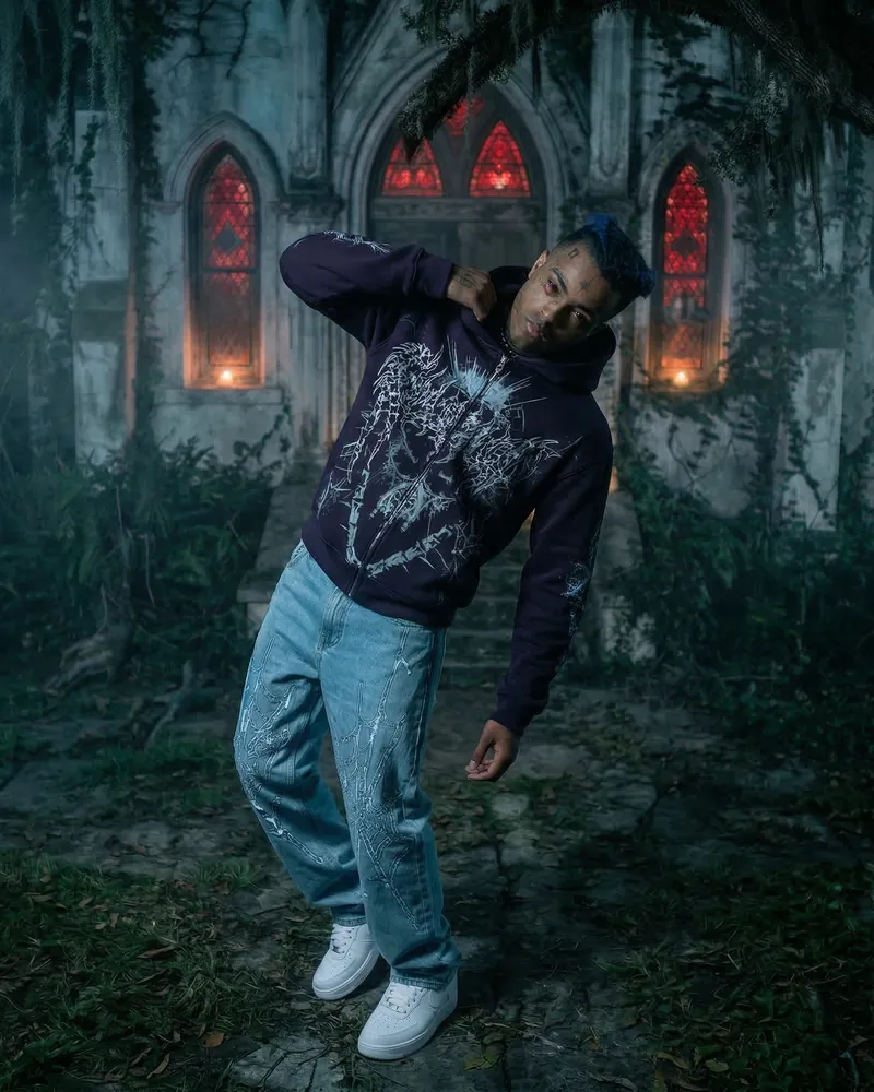 AI fashion photo: a model in a streetwear hoodie and jeans in front of a chapel with red windows, pose 4 of 6