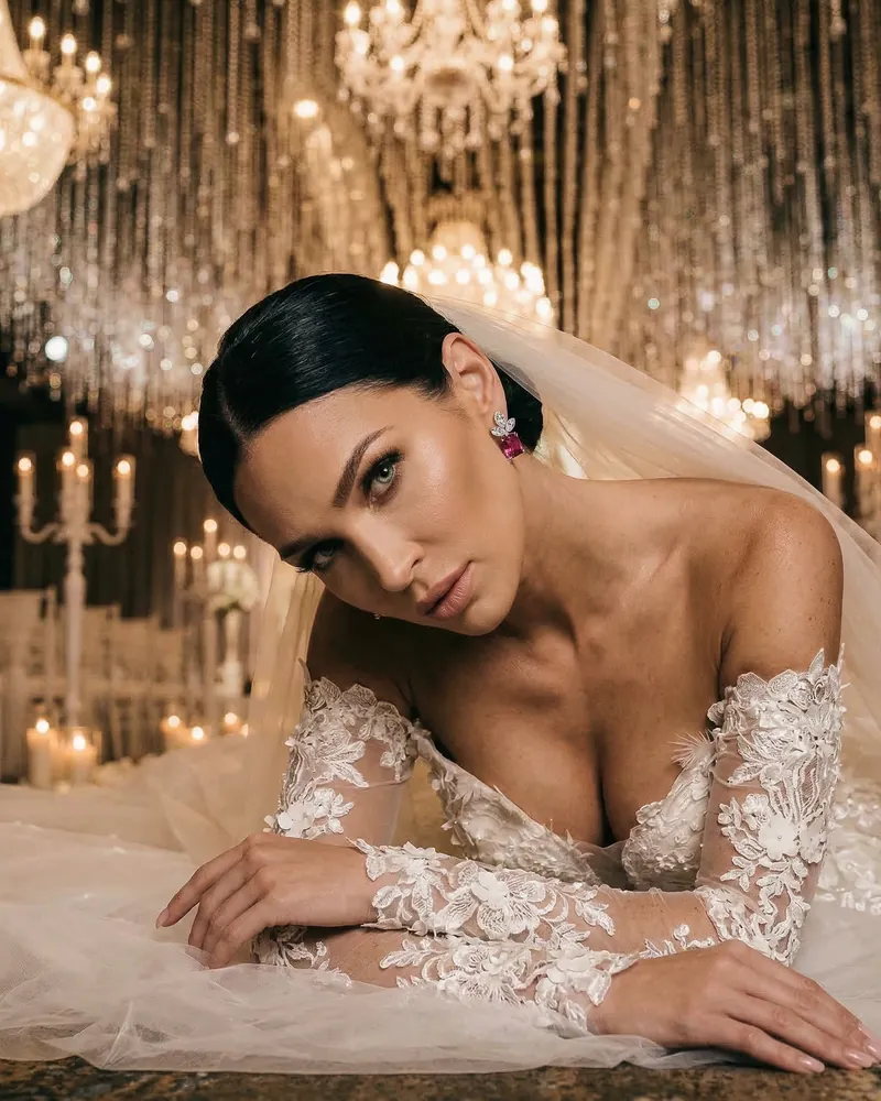 AI product photo: a bride with a veil lying among candles, wearing earrings and a necklace